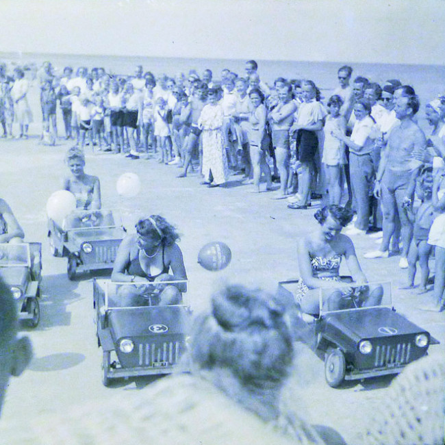 1950s-vintage-negative-girls-pedal-jeep-on-beach